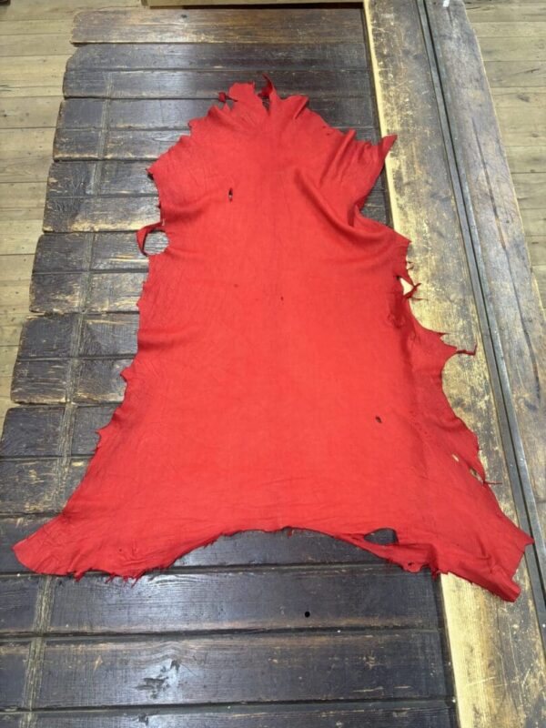 Red fabric laid on a wooden surface.
