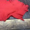 Red fabric lying on wooden surface.