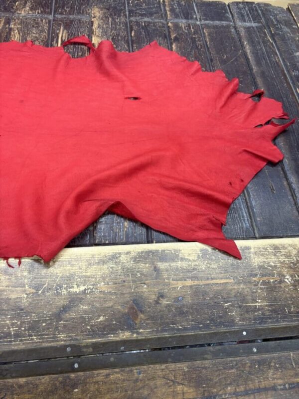 Red fabric lying on wooden surface.