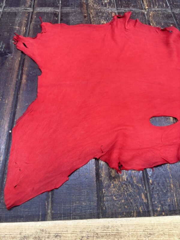 Red fabric laying on wooden surface.