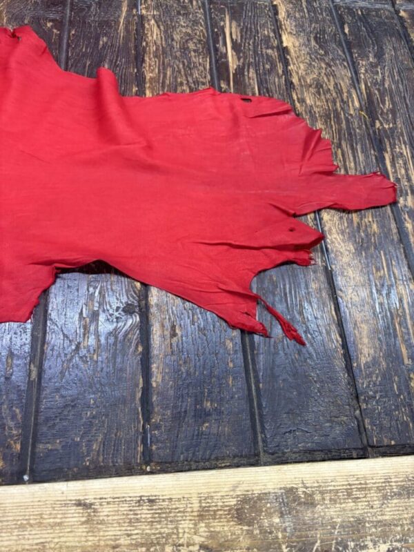 Tattered red fabric on wooden surface.