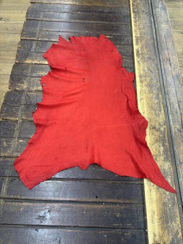 Red leather piece on wooden surface.