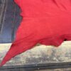Red fabric laid on a wooden surface.