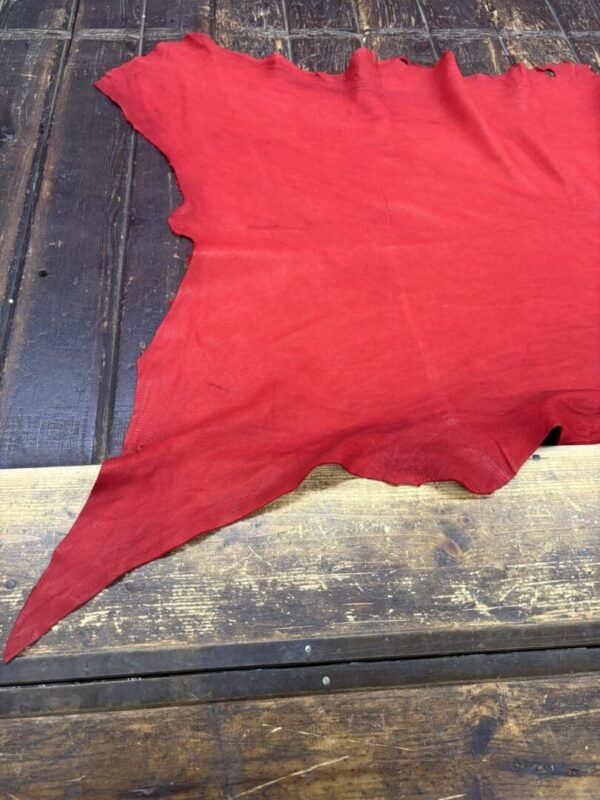 Red fabric laid on a wooden surface.