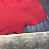 Red leather piece on wooden surface.