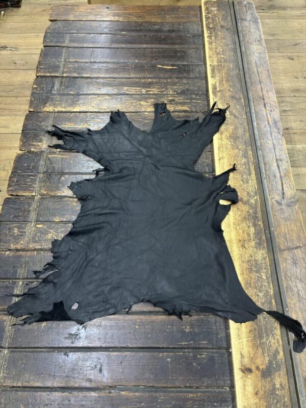 Black leather hide on wooden surface.