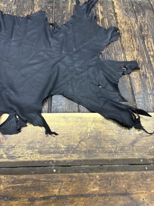 Black leather hide on wooden surface.