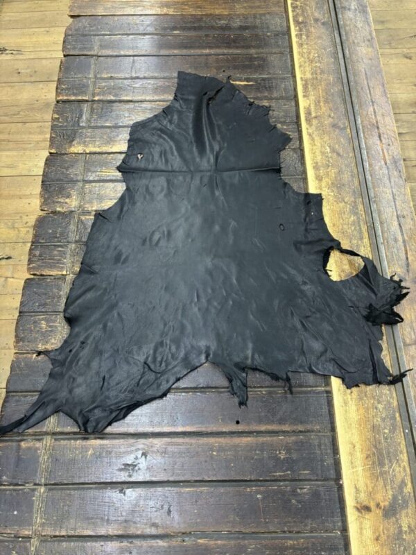 Black leather hide on wooden surface.