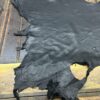 Black leather hide on wooden surface.
