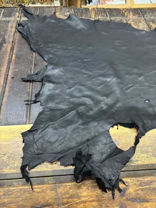 Black leather hide on wooden surface.