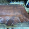 Brown leather hide on wooden table.