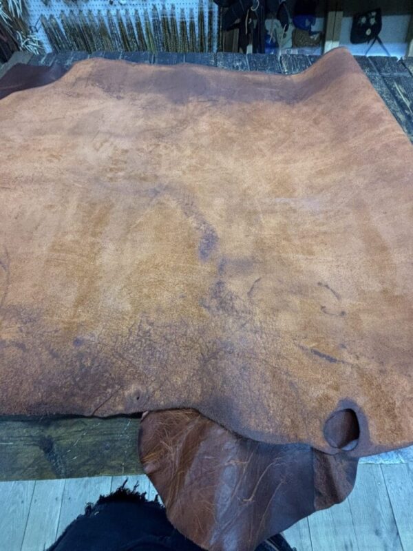 Brown leather laid on a wooden table.