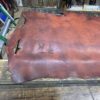 Leather hide on a wooden table surface.