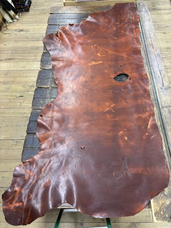 Brown leather hide on wooden table.