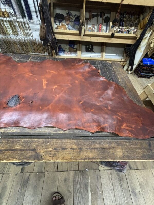 Tanned leather sheet on a wooden table.