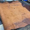 Brown leather sheet on wooden surface.