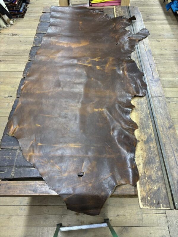 Brown leather hide on a wooden table.