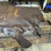 Leather hide displayed on a wooden table.