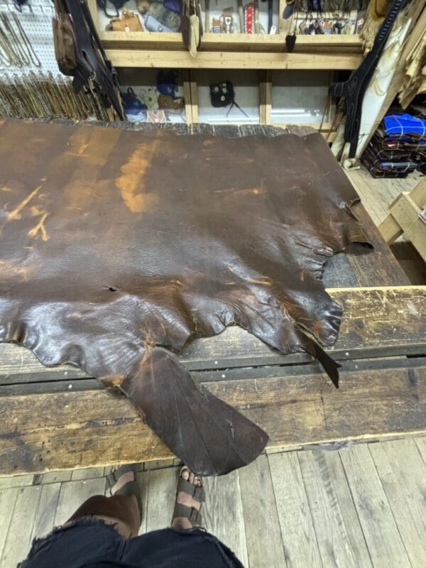 Leather hide displayed on a wooden table.