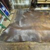 Leather hide on a workbench in workshop.