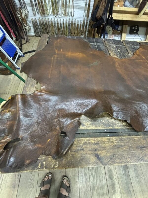 Brown leather hide on wooden table.