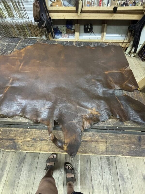 Brown leather hide on a wooden table.