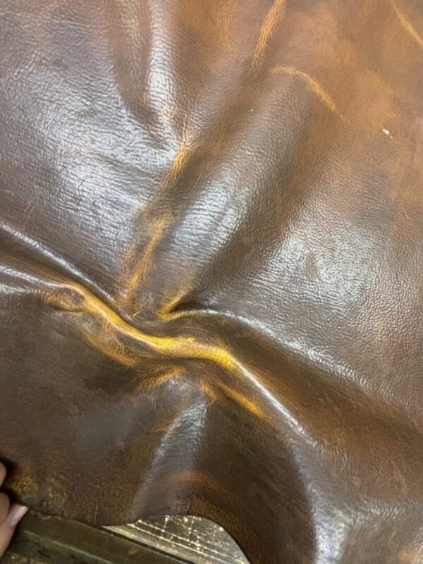 Wrinkled brown leather texture with shine.