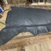 Black leather hide on wooden table.