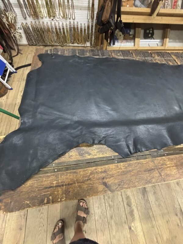 Black leather hide on wooden table.
