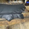 Black leather hide on wooden table.