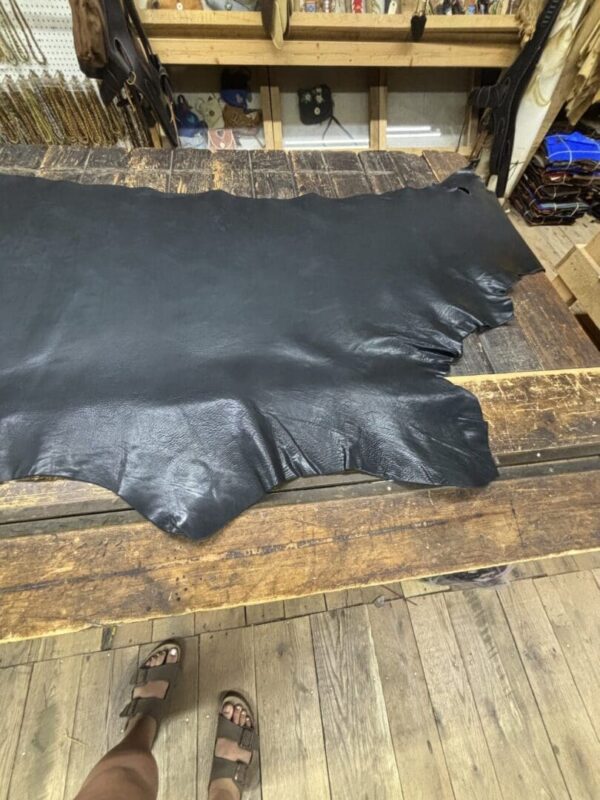 Black leather hide on wooden table.