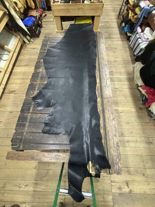 Black leather hide on wooden table.