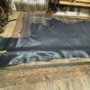 Black leather hide on wooden surface.