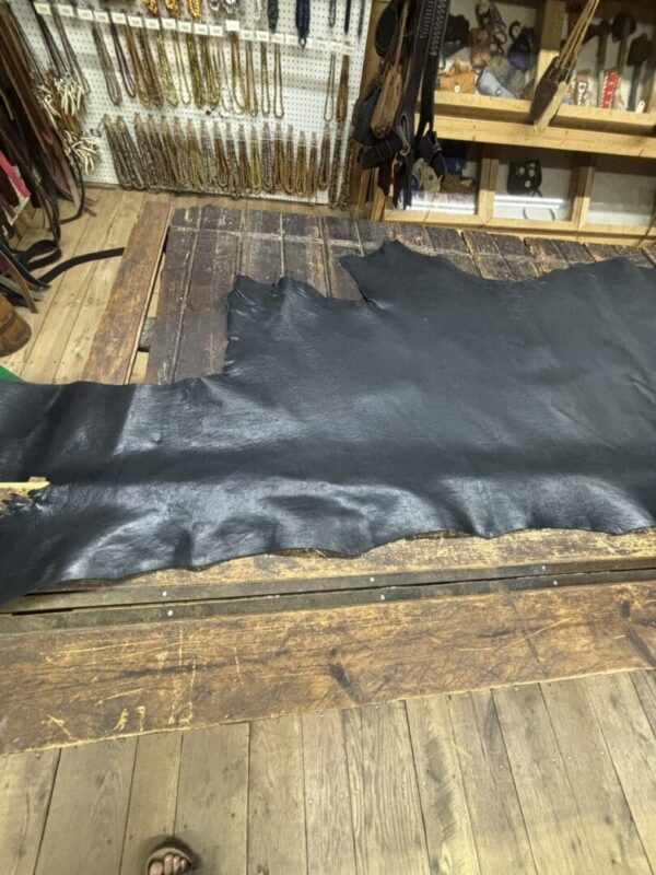 Black leather hide on wooden surface.