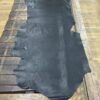 Black leather hide on wooden table.