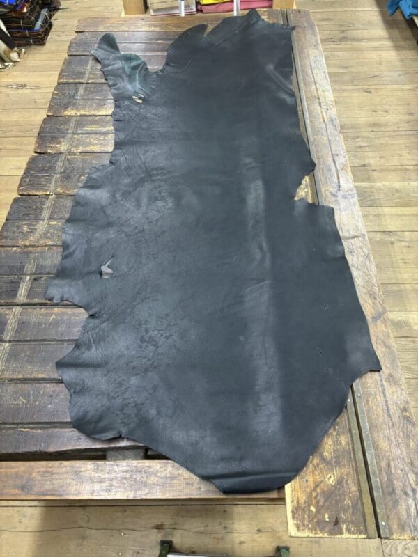 Black leather hide on wooden table.