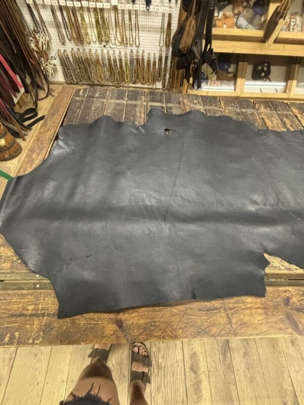 Black leather hide on wooden floor.