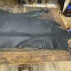 Black leather hide on wooden table.