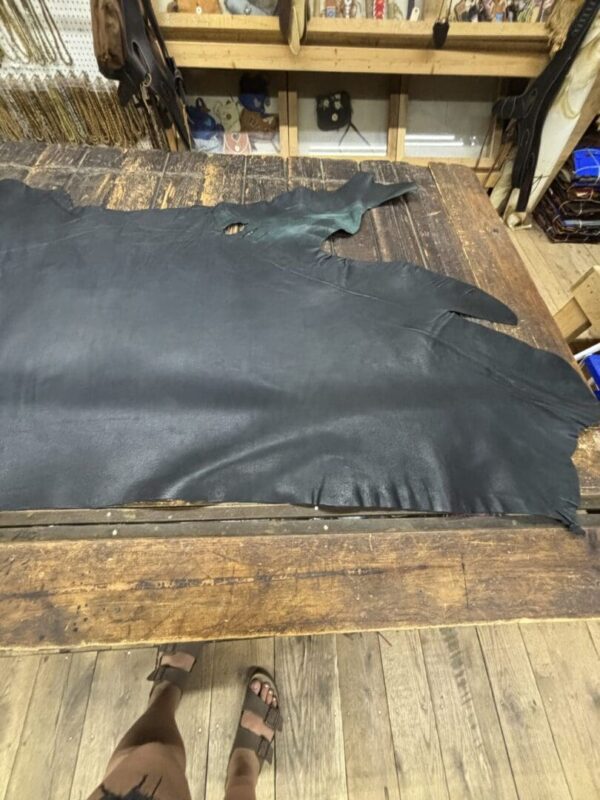 Black leather hide on wooden table.