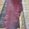 Red leather hide on wooden table.
