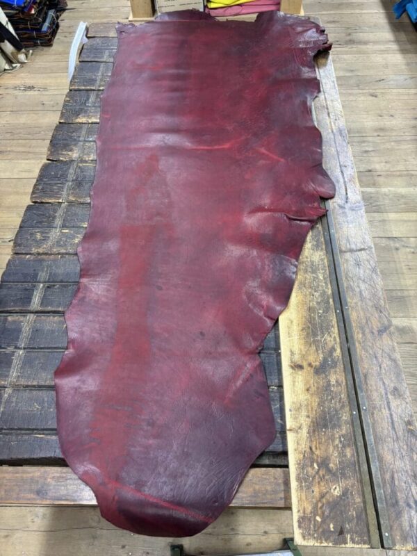 Red leather hide on wooden table.