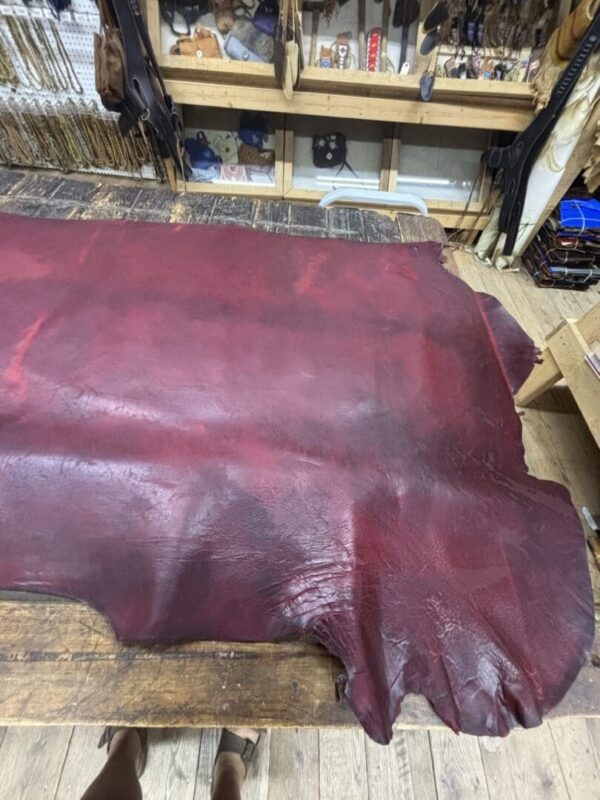 Burgundy leather hide on a wooden table.