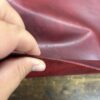 Closeup of red leather being folded.