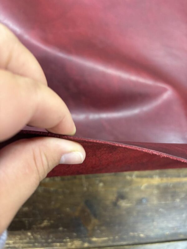 Closeup of red leather being folded.