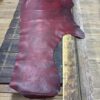 Burgundy leather hide on wooden surface.