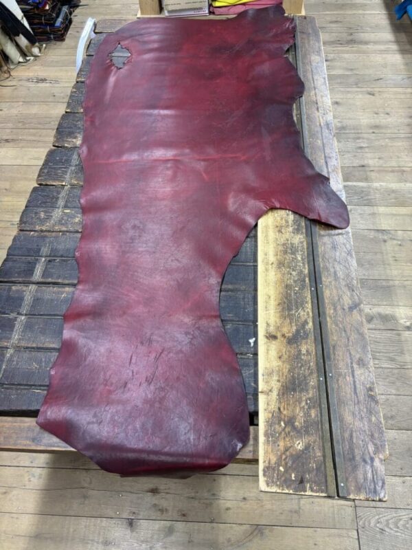 Burgundy leather hide on wooden surface.