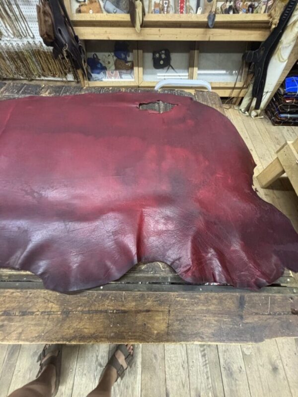 Red leather hide on wooden table.