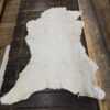 White fur rug on wooden floor.