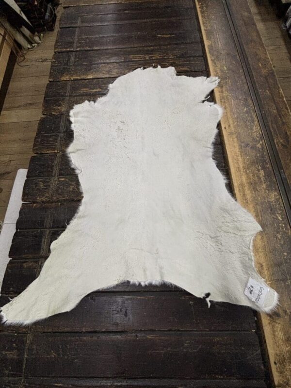 White fur rug on wooden floor.