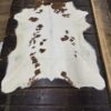 White cowhide rug with brown spots.